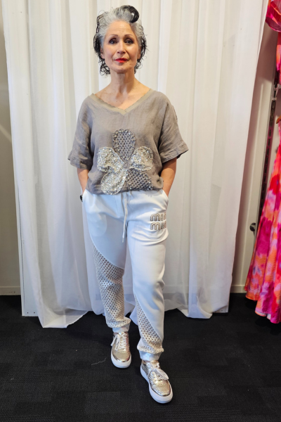 Person wearing a gray t-shirt with a decorative design and light blue pants against a white curtain background.
Italian Relaxed Lounge Pants White