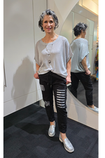 Woman in a gray oversized shirt and black ripped jeans standing in front of a mirror.
Italian Seq Pants Black