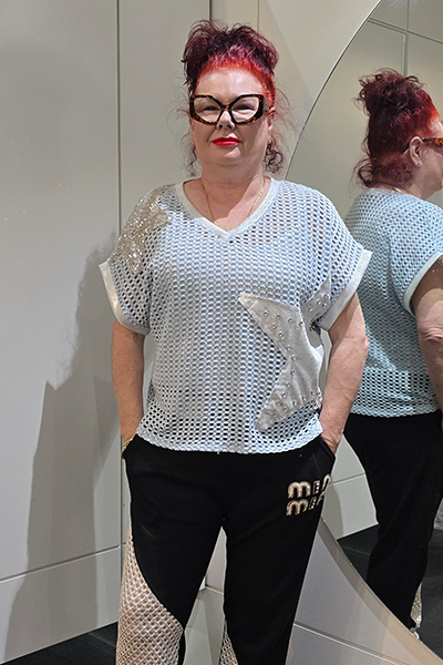 Person wearing a light gray mesh top with black pants, standing in front of a mirror.
Italian Metallic Stars Top Blue