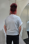 Person wearing a textured white top and black pants standing in front of a mirror.
Italian Metallic Stars Top Blue