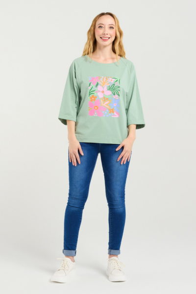 Woman wearing a light green sweatshirt with floral design and blue jeans on a white background
Kate T-Shirt Sage