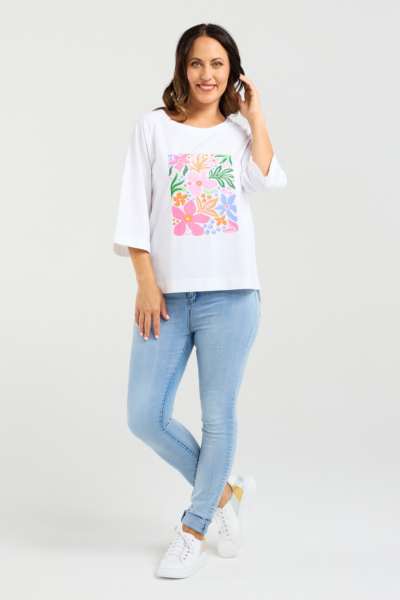 Woman wearing a white t-shirt with colorful floral design and light blue jeans on a white background
Kate T-Shirt White