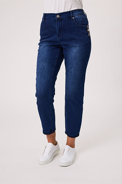 Person wearing blue jeans and white sneakers on a light gray background