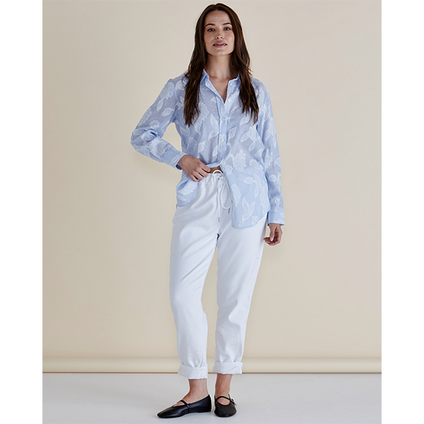 Woman wearing a light blue patterned shirt and white pants against a beige background
Lace Stripe Shirt Blue