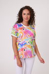 Woman wearing a colorful t-shirt with abstract designs on a white background Life Top Pink