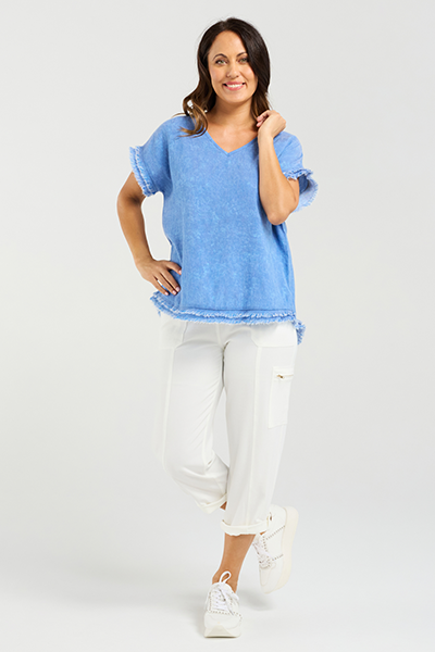 Woman wearing a blue top and white pants on a light gray background
Lilah Top Blue