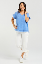 Woman wearing a blue top and white pants on a light gray background
Lilah Top Blue