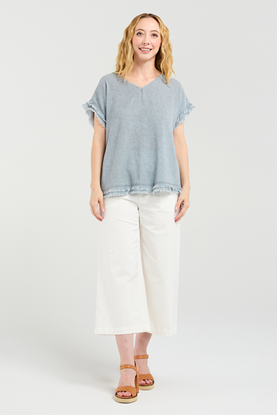 Woman wearing a light blue top and white pants on a white background
Lilah Top Grey