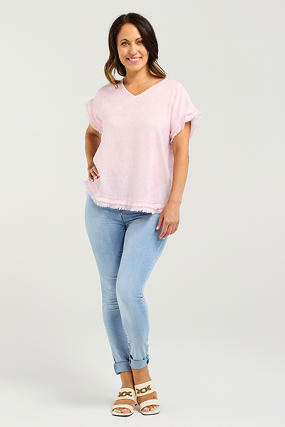 Woman wearing a light pink top and light blue jeans on a white background
Lilah Top Pink