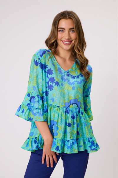 Woman wearing a blue and green floral blouse with ruffled sleeves on a white background Liliana Tiered Top Aqua