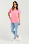 Woman wearing a pink t-shirt and light blue jeans on a white background Lily Top Pink