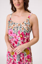 Woman wearing a floral dress with pink and multicolor flowers on a plain background
Maddie Dress Garden Print