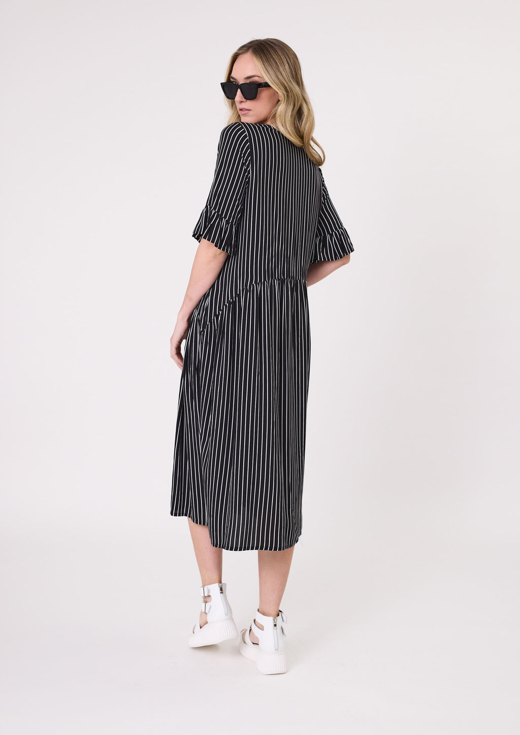 Woman wearing a black and white striped dress on a white background Madonna Dress Black/White Stripe