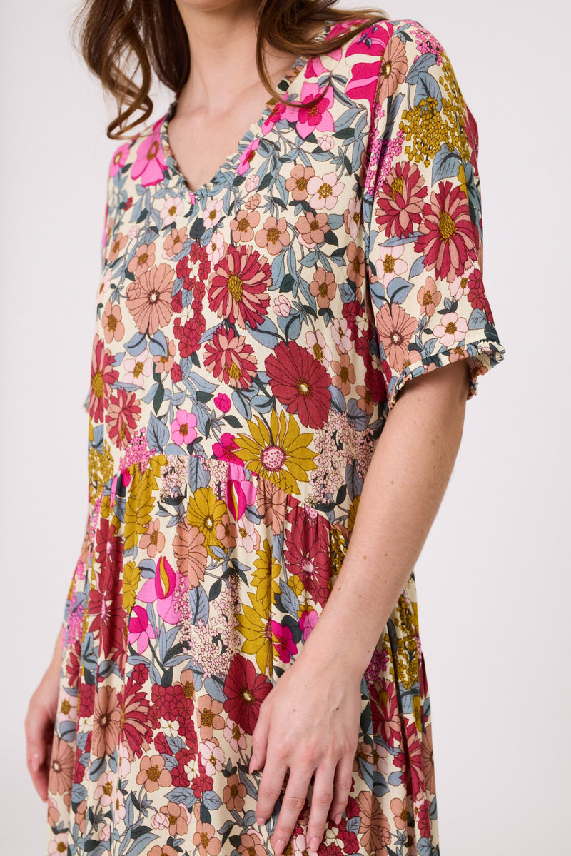 Woman wearing a colorful floral dress on a white background
Marissa Dress Garden Print
