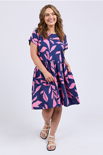 Woman wearing a navy dress with pink leaf pattern on a white background
Mimosa Dress Blue Depths