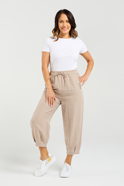 Woman wearing beige pants and a white t-shirt on a white background Nova Pants Natural