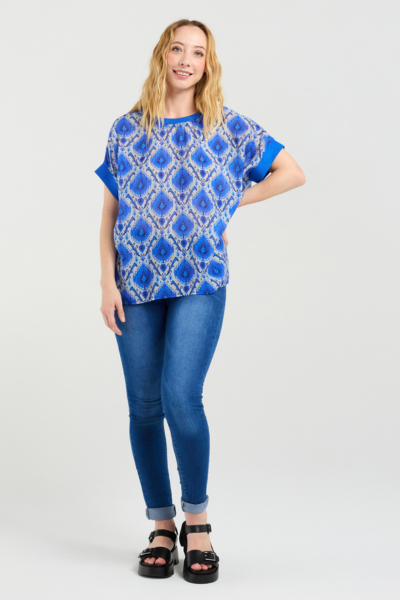 Woman wearing a blue patterned top and jeans on a white background
Olivia Top Paisley Painting