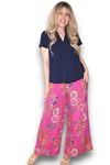 Woman wearing a navy shirt and pink floral pants on a white background Palazzo Doily Rose Pant Hot Pink