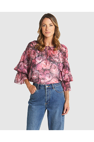 Woman wearing a floral blouse and blue jeans on a white background
Phenomenon Blouse Peony Pink