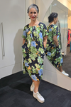 Woman wearing a floral dress standing in front of a mirror. Pleat Front Dress Black