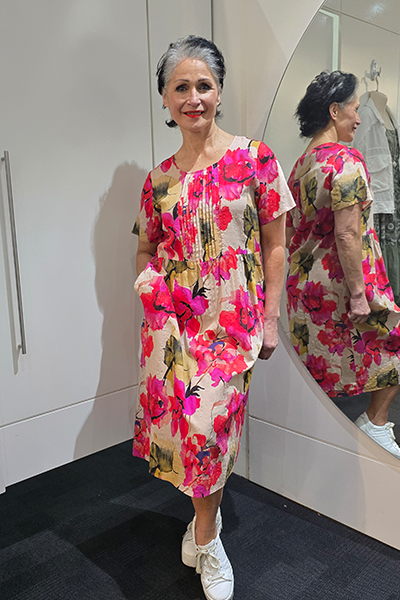 Woman in a floral dress standing in front of a mirror Pleat Front Dress Red