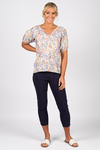Woman wearing a floral blouse and black pants on a white background
Printed V Neck Top Amalfi