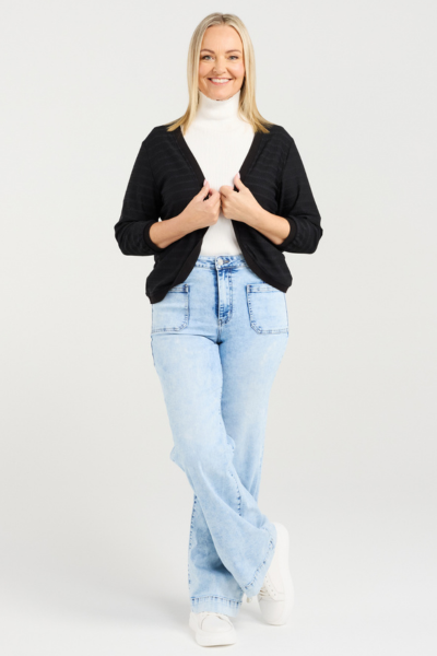Woman wearing a black cardigan, white turtleneck, and light blue jeans on a white background
Quinn Cardi Black
