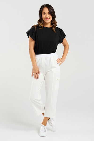 Woman wearing a black top and white pants on a plain background
Rhea Pants White