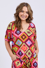 Woman wearing a colorful patterned dress on a white background
Rhode Top Geo Print