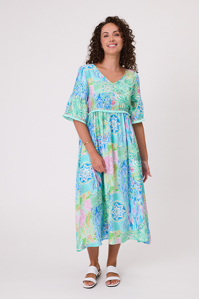 Woman wearing a colorful floral dress on a white background Rimini Tassel Dress-Aqua
