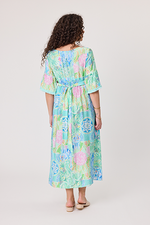 Woman wearing a colorful floral dress on a plain background Woman wearing a colorful floral dress on a white background Rimini Tassel Dress-Aqua