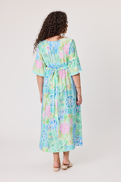Woman wearing a colorful floral dress on a plain background Woman wearing a colorful floral dress on a white background Rimini Tassel Dress-Aqua