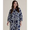 Woman wearing a navy and white patterned shirt dress on a plain background