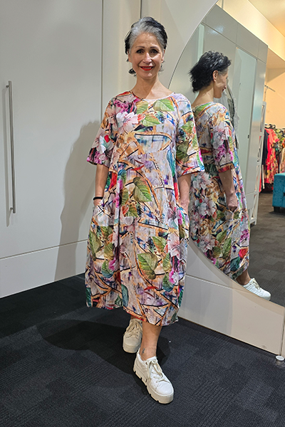 Woman wearing a colorful dress standing in front of a mirror. Round Neck Dress Multi