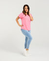 Woman wearing a pink t-shirt and blue jeans on a white background Lily Top Pink