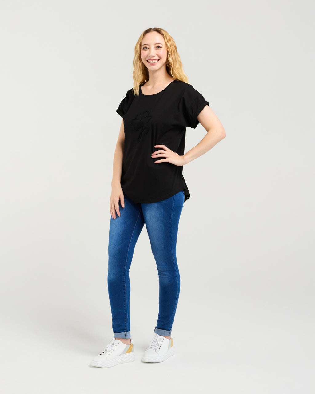 Woman wearing a black t-shirt and blue jeans on a white background Lily Top Black