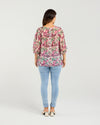 Woman wearing a floral blouse and light blue jeans on a white background
Ariel Top Rose Garden