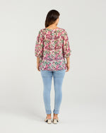 Woman wearing a floral blouse and light blue jeans on a white background
Ariel Top Rose Garden