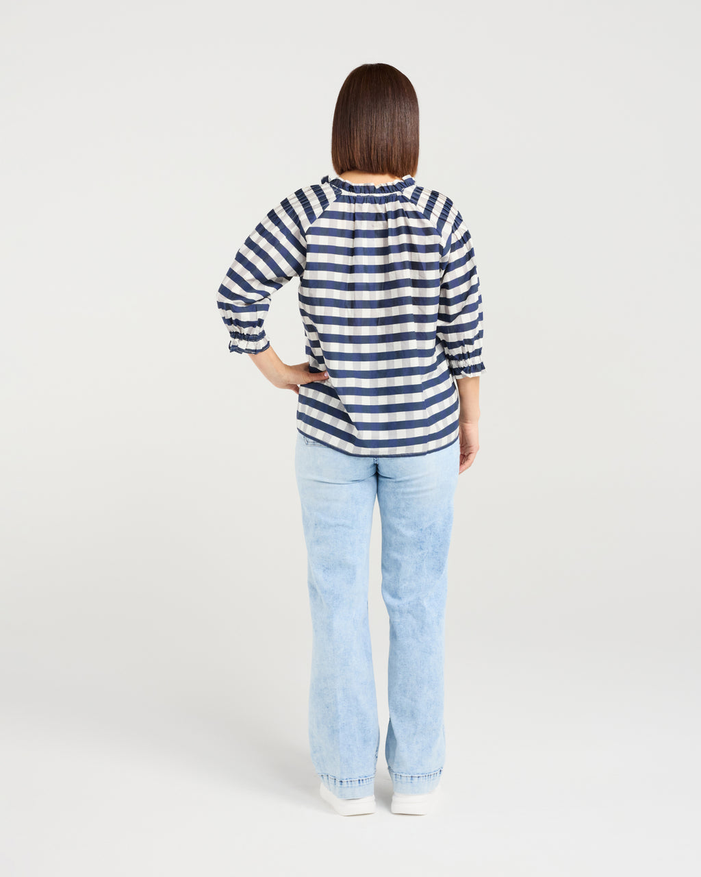 Woman wearing a blue and white striped shirt and light blue jeans on a white background Claire Top Ink Check