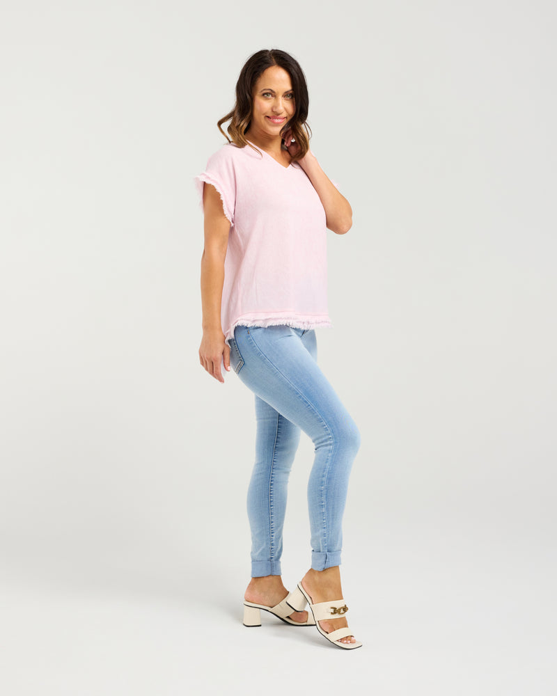 Woman wearing a pink top and light blue jeans on a white background
Lilah Top Pink