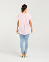 Person wearing a light pink t-shirt and light blue jeans on a white background
Lilah Top Pink