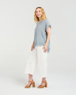Woman wearing a blue top and white pants on a plain background
Lilah Top Grey