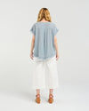 Woman wearing a light blue top and white pants on a white background
Lilah Top Grey