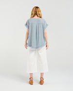Woman wearing a light blue top and white pants on a white background
Lilah Top Grey