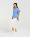 Woman wearing a blue top and white pants on a plain background
Lilah Top Blue