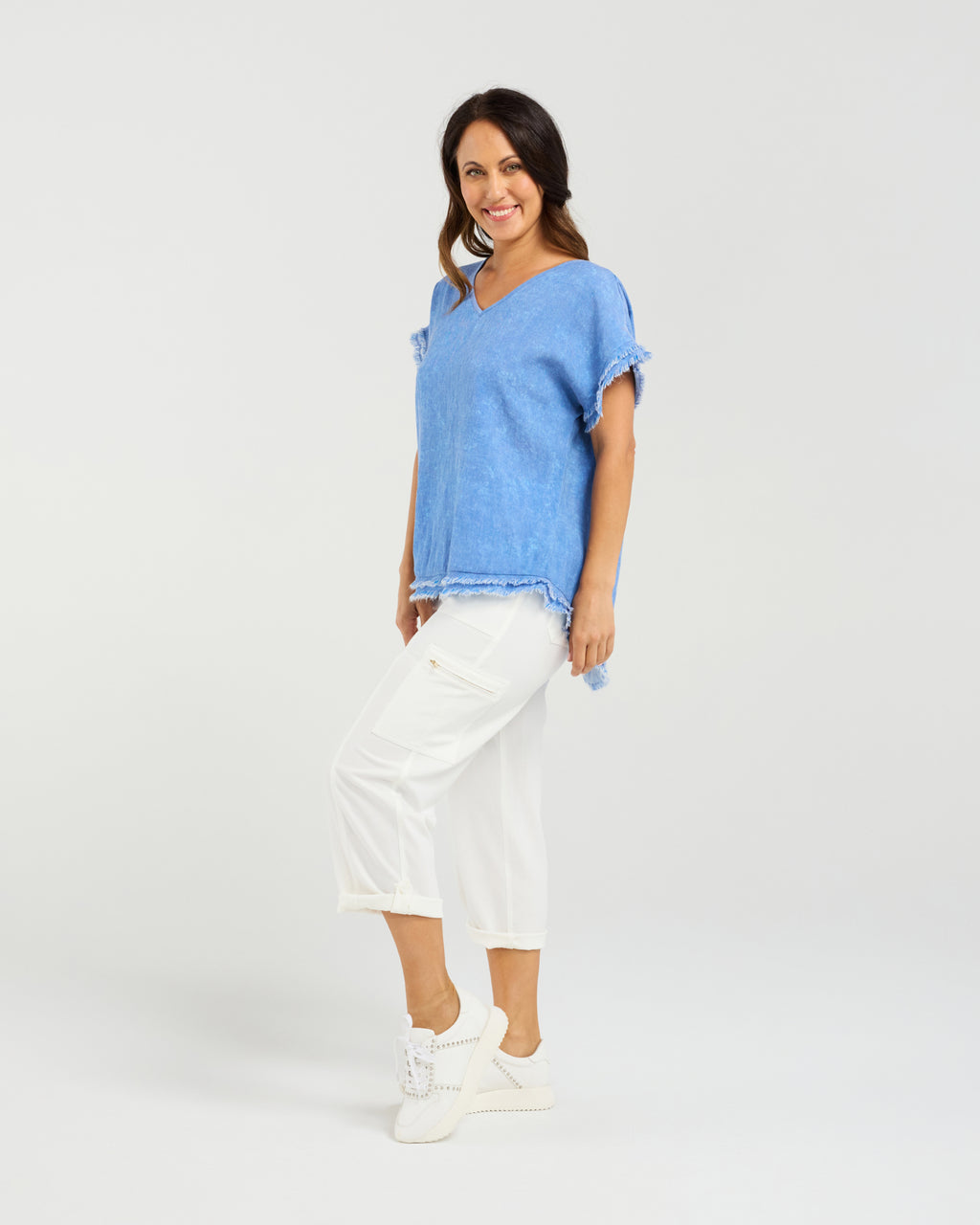 Woman wearing a blue top and white pants on a plain background
Lilah Top Blue