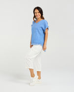 Woman wearing a blue top and white pants on a plain background
Lilah Top Blue