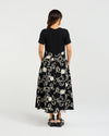 Woman wearing a black dress with white floral patterns on a white background
Delilah Dress Black Garden