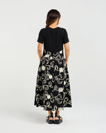 Woman wearing a black dress with white floral patterns on a white background
Delilah Dress Black Garden