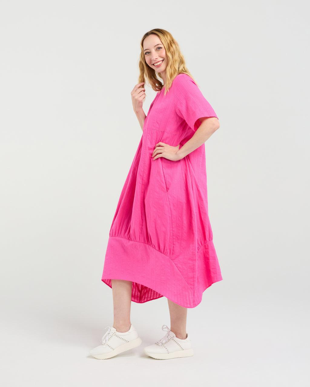 Woman wearing a bright pink dress on a white background Selena Dress Hot Pink